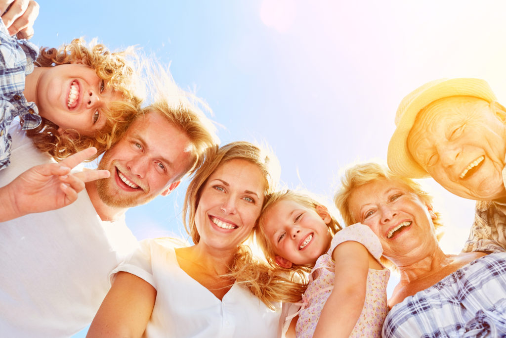 Glückliche lachende Familie mit Kindern und Großeltern zusammen im Sommer